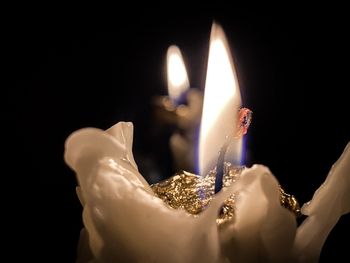 Close-up of burning candle in darkroom