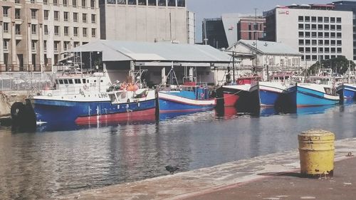 Boats moored at harbor by sea