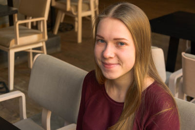 Portrait of smiling young woman sitting at cafe