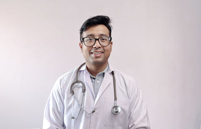 Portrait of smiling man standing against wall