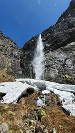 Scenic view of waterfall against sky