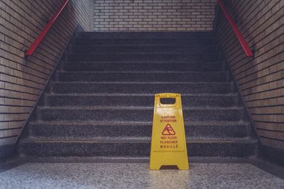 High angle view of wet floor sign by steps