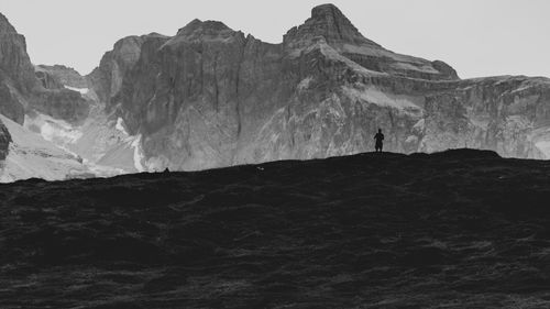 People on rock formation against sky