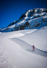 Person skiing on snowcapped mountain against sky