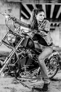 Full length portrait of young woman riding motorcycle