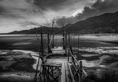 Wooden pier over lake against sky