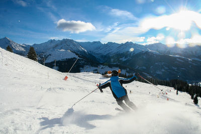 Rear view of person skiing on mountain against sky