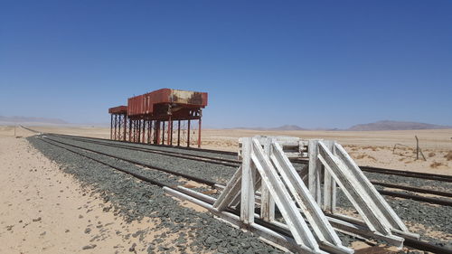 Metallic structure on land against clear blue sky