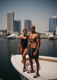 Full length of shirtless man standing in water against sky