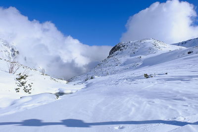 Scenic view of snow covered mountains against sky