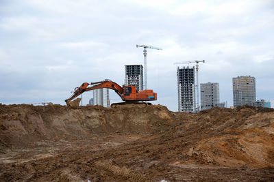 Cranes at construction site against sky