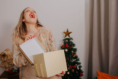 Woman holding christmas tree in box