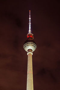 Low angle view of communications tower against sky at night