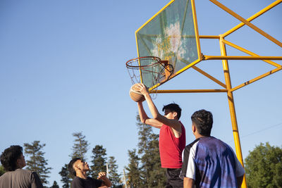 Group of teenagers playing basketball