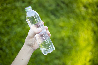 Close-up of hand holding glass bottle
