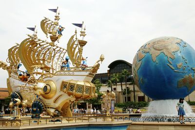 Statue in city against sky