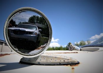 Close-up of reflection of car on side-view mirror