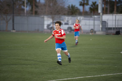 Teen soccer player jogging on the field during a game