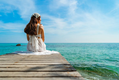 Rear view of woman in sea against sky