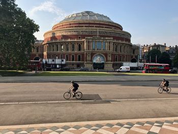 People riding bicycle on road in city
