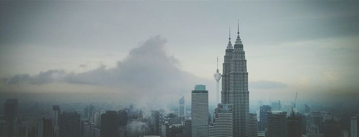 Modern buildings against cloudy sky