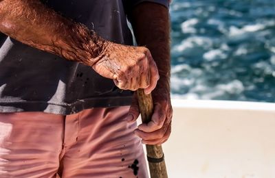 Midsection of man holding stick