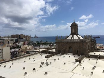 Built structure by sea against cloudy sky