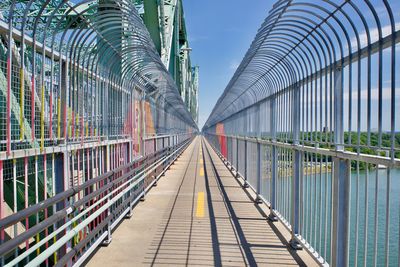 Footbridge against sky in city