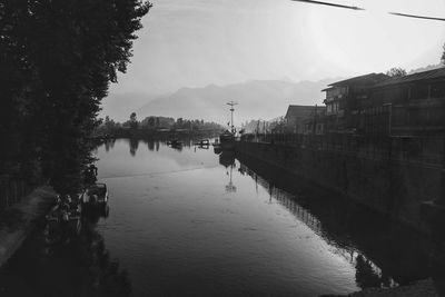 Scenic view of river by city against sky