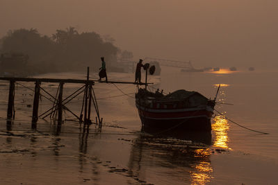 Boats in sea during sunset