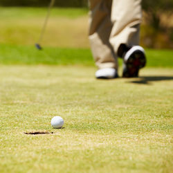 Low section of man playing golf on field