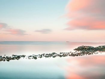 Scenic view of calm sea against sky during sunrise