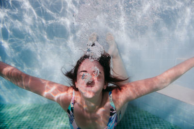 Portrait of a smiling young woman swimming in pool