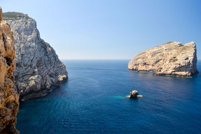 High angle view of rock formation in sea against clear sky