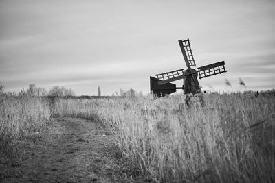 Old dutch windmill on field against sky