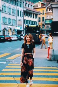 Portrait of smiling young woman on street in city