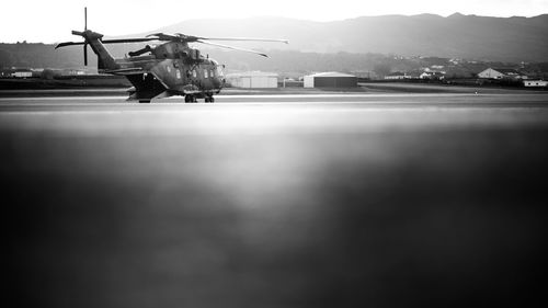 Military helicopter on airport runway against mountains