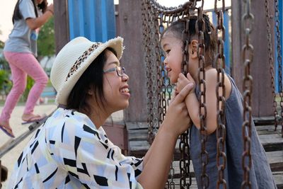 Mother with daughter on jungle gym at park