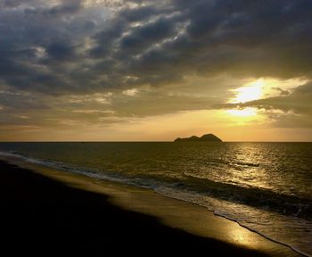 Scenic view of sea against dramatic sky during sunset