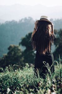 Rear view of woman standing by plants