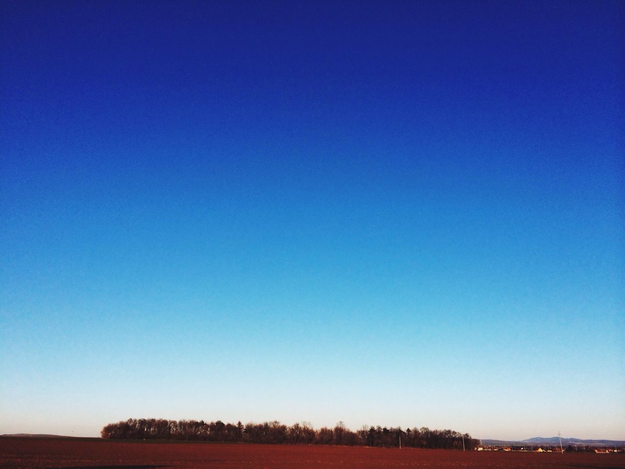 clear sky, copy space, blue, tranquil scene, landscape, tranquility, scenics, field, beauty in nature, nature, horizon over land, tree, non-urban scene, outdoors, remote, idyllic, no people, solitude, dusk, rural scene