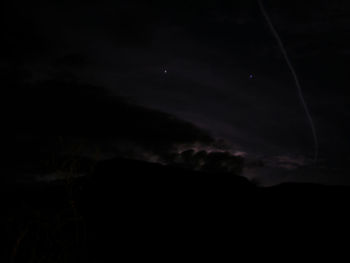 Low angle view of silhouette moon against sky at night