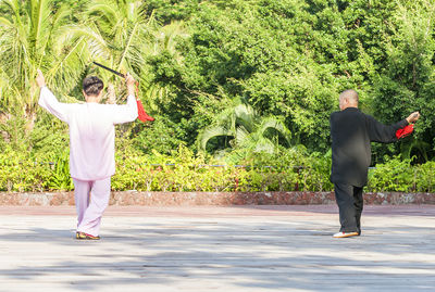 Rear view of man and woman standing by plants