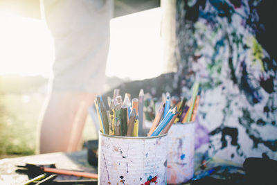 Midsection of person painting with colored pencils in foreground