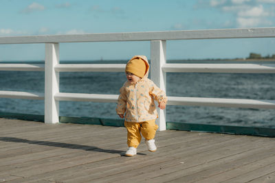 Rear view of woman standing on railing