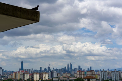 Buildings in city against cloudy sky