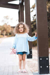 Girl standing near column at park