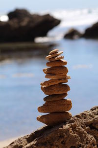 Close-up of stones stacked on rock by river