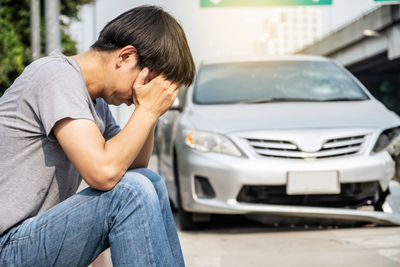 Side view of man sitting in car