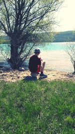 Rear view of man sitting on grass